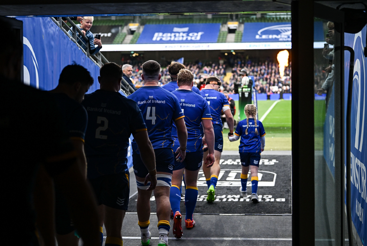 Leinster Rugby players walking out of the tunnel with a young mascot